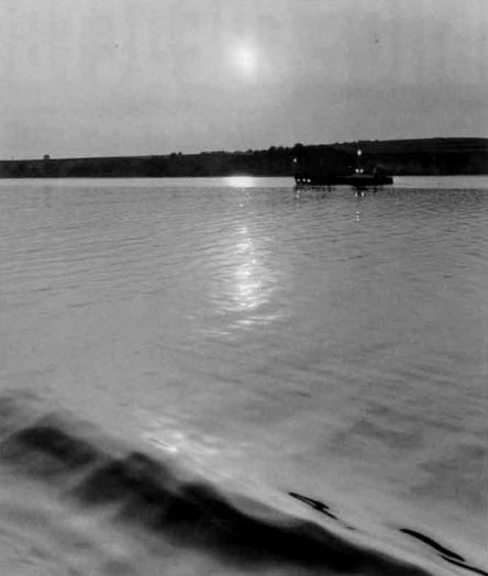 Снимок сделан примерно за 1 час до захода солнца, нормальный объектив, f/8, без светофильтра, пленка 125 ед. ГОСТа. Эффект ночи был получен в результате точного подбора экспозиции. „Огни“ на судне, как и их отражения, созданы искусственно путем нанесения на отпечаток точек аптечной настойки йода остро отточенной спичкой. Образовавшееся на этих местах бурое йодистое серебро было обесцвечено в растворе гипосульфита.