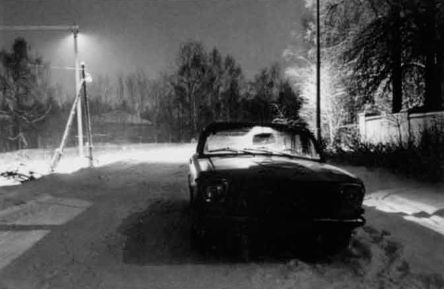 Нормальный объектив, f/8, без светофильтра, пленка 130 ед. ГОСТа. Январь, около 24 часов. Выдержка 2 мин. Пример того, что даже очень светлый объект может быть использован для получения снимка в темной тональности. И дорога, и деревья, покрытые инеем, и светлая автомашина получились на снимке темными, поскольку свет от уличных фонарей падал только на небольшой участок дороги позади автомашины. Для большего эффекта внутри салона автомобиля был зажжен свет. Съемка производилась со штатива.