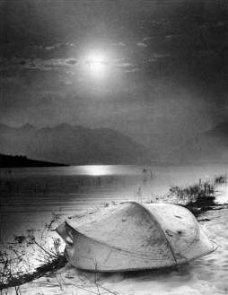 Солнце снято в вечернее время, когда оно прикрыто полосой облаков.